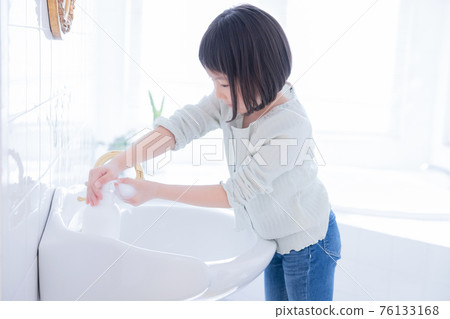 Girl washing hands in the washroom 76133168