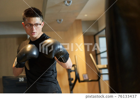 亞洲男子在沙袋前舉行 76133437