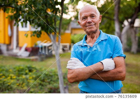 Elderly gardener posing in his garden 76135609