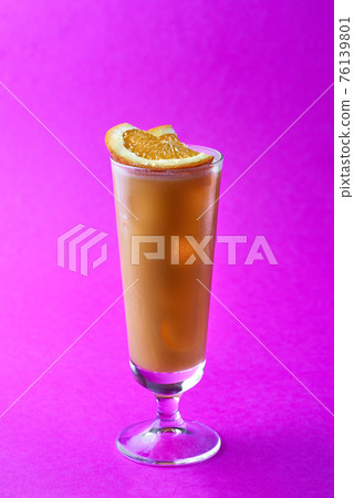 Orange and coffee cocktail topping sliced orange on a purple background. 76139801
