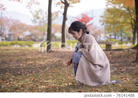 A woman who feels the arrival of autumn and hunting for autumn leaves A woman who feels the arrival of autumn and hunting for autumn leaves 76141486