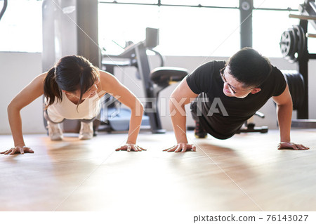 Asian couple doing push-ups in pairs Asian couple doing push-ups in pairs 76143027