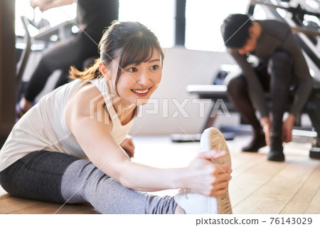 Asian woman stretching in a training gym 76143029