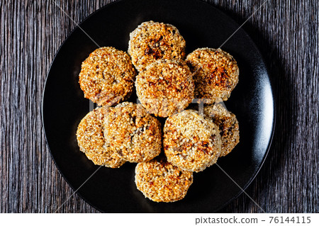 sesame lamb patties on a black plate sesame lamb patties on a black plate 76144115