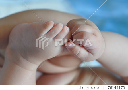Small baby feet and hands on light blue background Small baby feet and hands on light blue background 76144173
