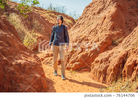Man tourist in red canyon, resumption of tourism concept 76144706