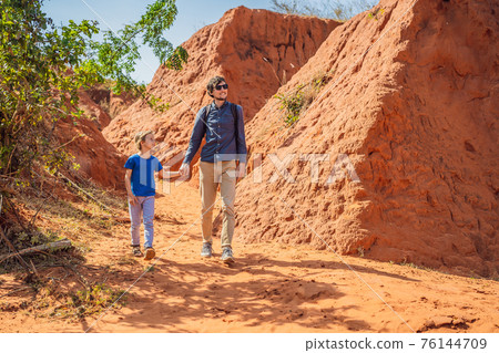 Dad and son tourists in red canyon, resumption of tourism concept. Traveling with children concept 76144709