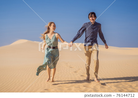 Happy couple healthy lifestyle affectionate outdoors in nature during hiking travel. Man and woman hikers smiling in mountain desert landscape. Tourism opens after quarantine COVID 19 76144712