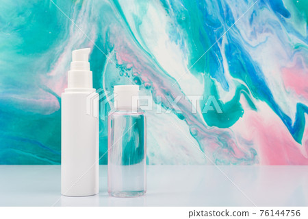 Face cream and lotion on white table against blue marbled background with copy space. Face cream and lotion on white table against blue marbled background with copy space. 76144756