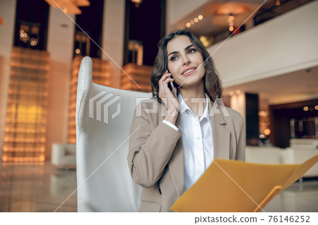 Pretty businesswoman scrutinizing the project details and looking interested Pretty businesswoman scrutinizing the project details and looking interested 76146252