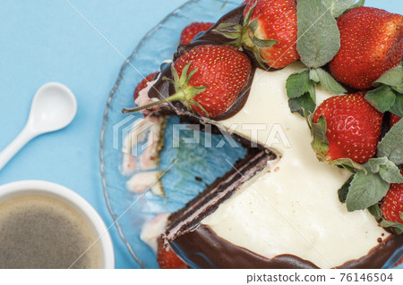 Homemade chocolate cake decorated with fresh strawberries and cup of coffee 76146504