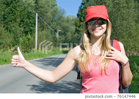 girl with rucksack stops the car 76147446