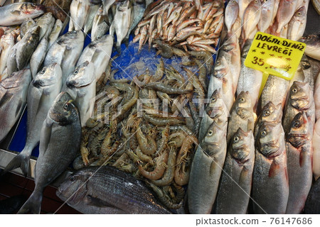 Closeup of various fresh raw sea fish and shrimps with Turkish price labels. The fish market in Istanbul, Turkey Closeup of various fresh raw sea fish and shrimps with Turkish price labels. The fish market in Istanbul, Turkey 76147686
