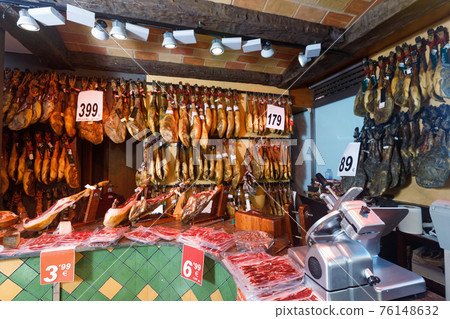 Assortment of traditional Spanish meat shop with dangling legs jamon Assortment of traditional Spanish meat shop with dangling legs jamon 76148632