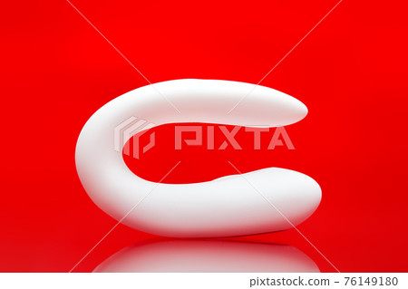 clitoral vaginal vibrator white silicone intimate gadget sex toy for couple, erotic object for adults isolated on red background with reflection, nobody. clitoral vaginal vibrator white silicone intimate gadget sex toy for couple, erotic object for adults isolated on red background with reflection, nobody. 76149180
