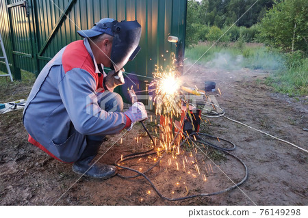 arc welding is a power tool, welding a metal fence, construction work. 76149298