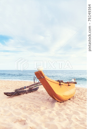 Small fishing boat on an empty beach, color toning applied, Sri Lanka. Small fishing boat on an empty beach, color toning applied, Sri Lanka. 76149364