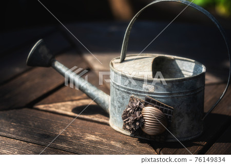 Tin watering can on the table in the botanical garden 76149834