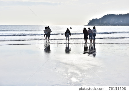 Silhouettes of young women playing on the Kamakura Yuigahama coast 76151508