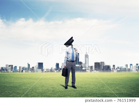 Camera headed man standing on green grass against modern citysca Camera headed man standing on green grass against modern citysca 76151999