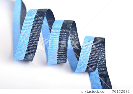Blue Cotton ribbon, roll textilies on bobbin. strapping tape with curl on white backgroud. Blue Cotton ribbon, roll textilies on bobbin. strapping tape with curl on white backgroud. 76152981
