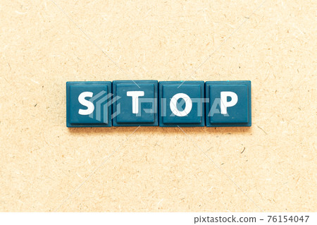Tile alphabet letter in word stop on wood background Tile alphabet letter in word stop on wood background 76154047