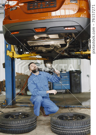 Checking car for serviceability in garage with tools on hoist 76157271