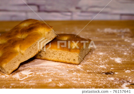 Italian Focaccia bread on a table with flour Italian Focaccia bread on a table with flour 76157641