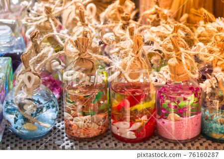 Plenty of small colorful decorative bottles on shelf 76160287