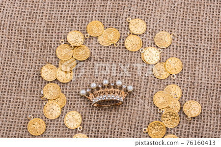 Crown in the middle of golden coins in a textured background Crown in the middle of golden coins in a textured background 76160413