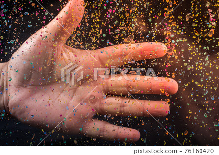 Hand on a glass with a paint splash effect on black background Hand on a glass with a paint splash effect on black background 76160420