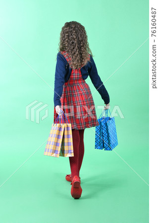 Child with a packaging checkered texture isolated on white background. Girl likes shopping on sale season. Holiday present, shopping. Child with a packaging checkered texture isolated on white background. Girl likes shopping on sale season. Holiday present, shopping. 76160487