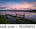 Color image of a fence in a flooded field at sunset. 76160655