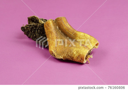 Natural healthy treats for dogs of premium quality. Dried beef stomach, buffalo tripe on a pink background. 76160806