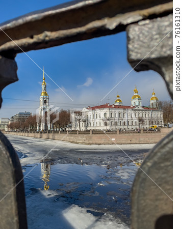 St. Nicholas Naval Cathedral belltower through the forged lattice in a clear sunny day of spring, an ice drift on Kryukov and Griboyedov Canal, a view of seven bridges from the embankment St. Nicholas Naval Cathedral belltower through the forged lattice in a clear sunny day of spring, an ice drift on Kryukov and Griboyedov Canal, a view of seven bridges from the embankment 76161310