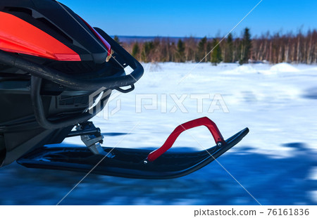 snowmobile ski while driving on snowy winter landscape 76161836