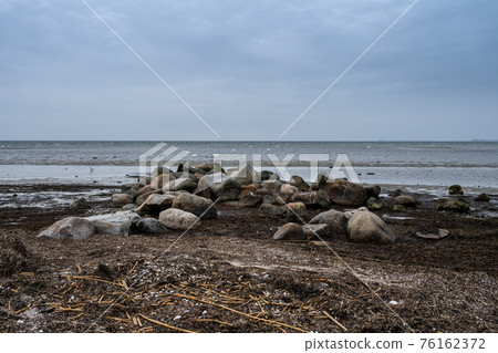 Boulders at Lomma Beach, Malmo, Sweden. Blue sky and ocean in the background Boulders at Lomma Beach, Malmo, Sweden. Blue sky and ocean in the background 76162372