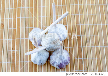 fresh white garlic heap on wooden background vegetable set fresh white garlic heap on wooden background vegetable set 76163370