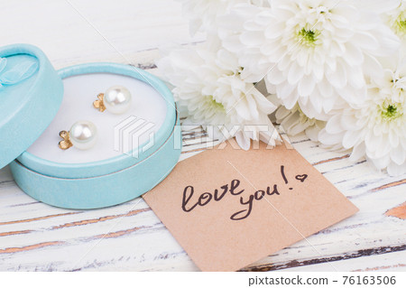 Flowers, pearl earrings and love message. Flowers, pearl earrings and love message. 76163506