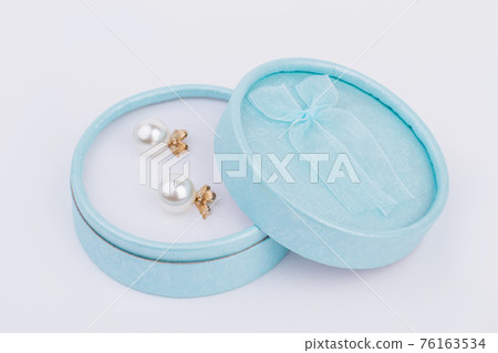 Golden earrings in jewelry box. 76163534