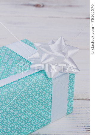 Gift box of turquoise color with white bow. Gift box of turquoise color with white bow. 76163570