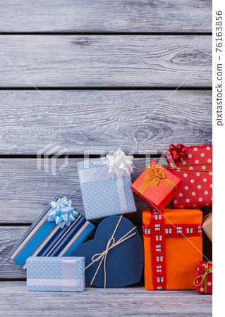 Pile of gift boxes on wooden background. Pile of gift boxes on wooden background. 76163856
