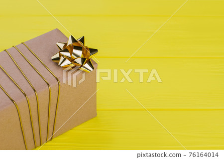 Gift box in kraft paper with golden stripe. Gift box in kraft paper with golden stripe. 76164014