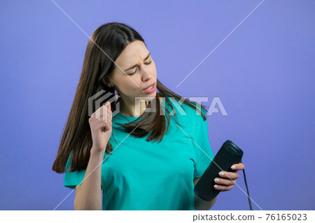 Woman listening to music by wireless portable speaker - modern sound system. Lady dancing, enjoying Woman listening to music by wireless portable speaker - modern sound system. Lady dancing, enjoying 76165023