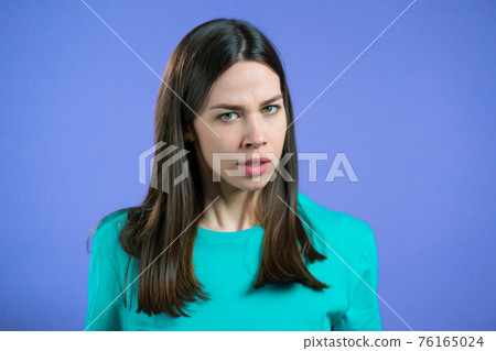 Furious woman on violet background. Lady in stress and rage, she threatens with aggression and 76165024