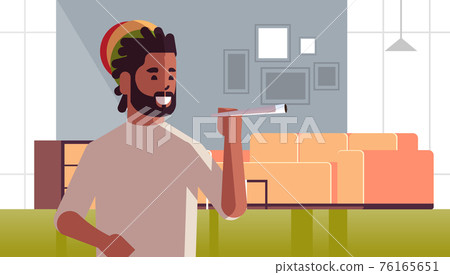 african american guy smoking cannabis marijuana joint drug consumption concept modern living room interior portrait horizontal 76165651