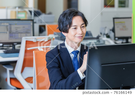 通過在辦公室看電腦屏幕工作的商人 76166149