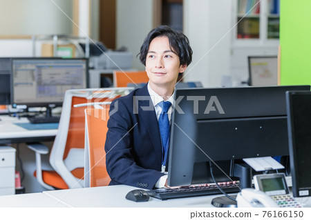 通過在辦公室看電腦屏幕工作的商人 通過在辦公室看電腦屏幕工作的商人 76166150