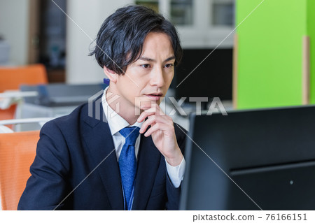 通過在辦公室看電腦屏幕工作的商人 通過在辦公室看電腦屏幕工作的商人 76166151