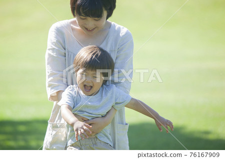 Parents and children playing on the grass in summer Parents and children playing on the grass in summer 76167909